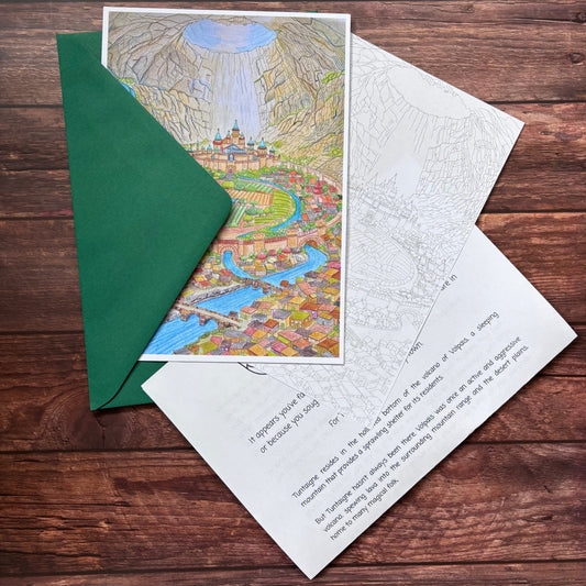 Greeting card with map design and green envelope on wooden surface